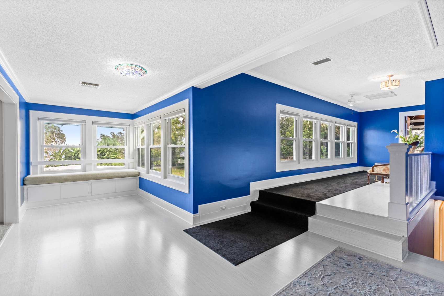room with bright blue walls and black long rug